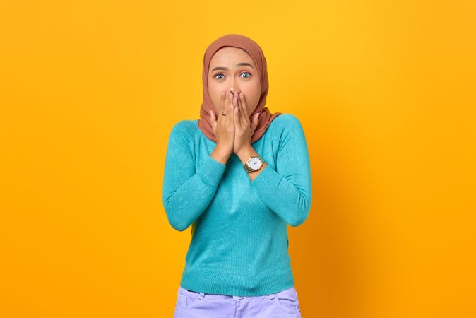 Surprised Muslim woman covering her mouth