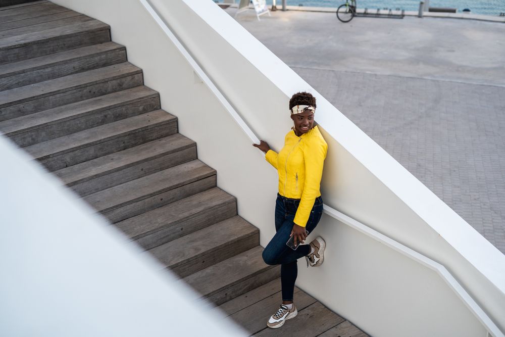 Satisfied female having rest on stairs in city