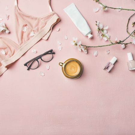 Feminine products and undergarments laid out over pink background