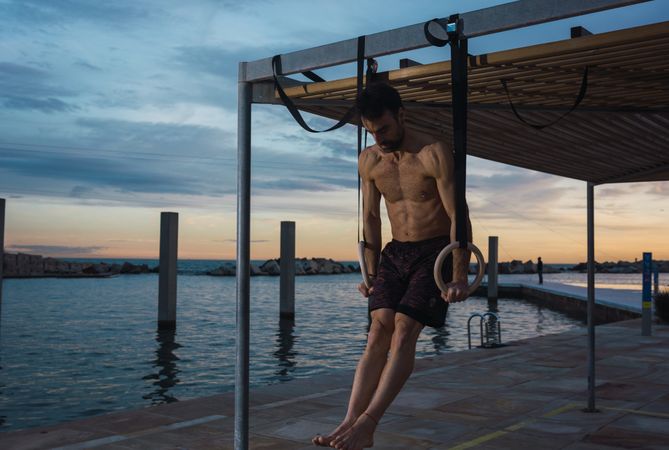 Athletic man balancing on gymnastic rings