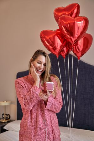 Happy female rejoicing at Saint Valentine gifts in hotel