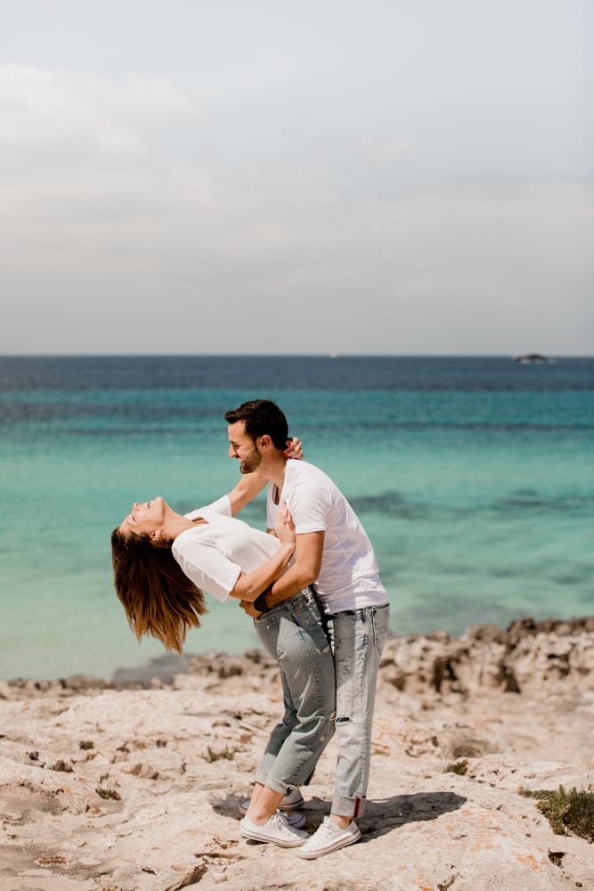 Laughing lovers hugging on beach