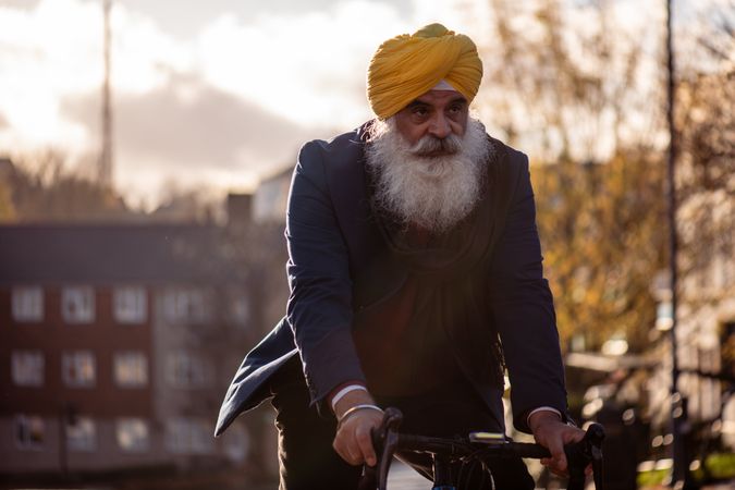 Mature Sikh man cycling through British town