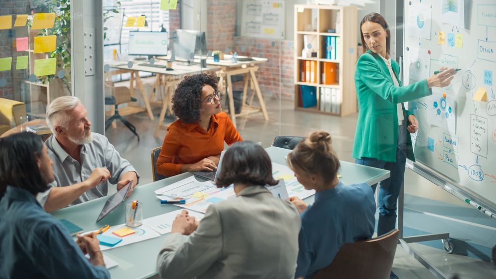 Driven Visionary Businesswoman Leading a Team Meeting in Creative Office Conference Room.