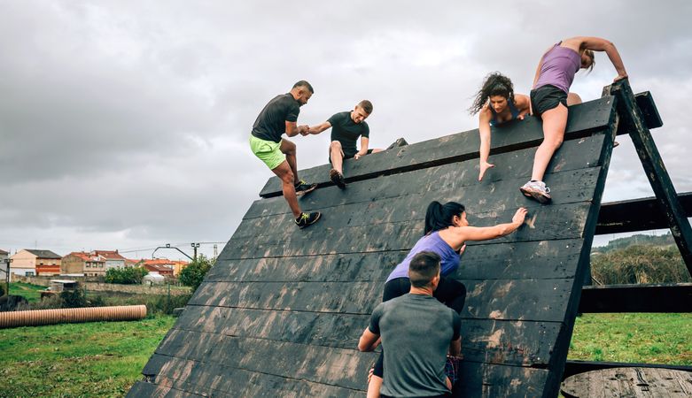Participants in obstacle course climbing pyramid obstacle