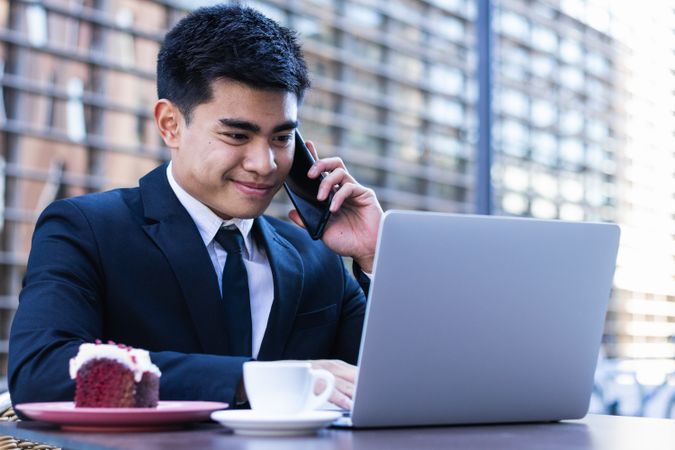 Cheerful Asian businessman working in cafe