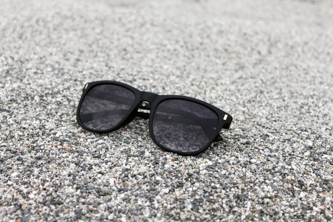 Sunglasses sitting on grey beach