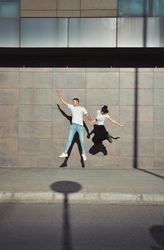 Couple jumping for joy in the streets.