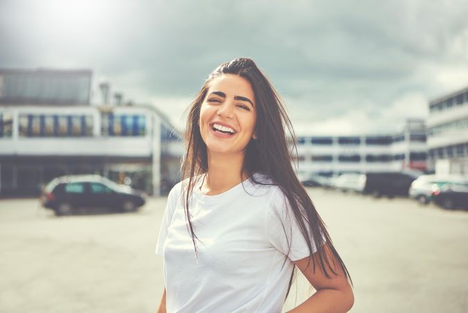 Radiant brunette woman smiling in parking lot