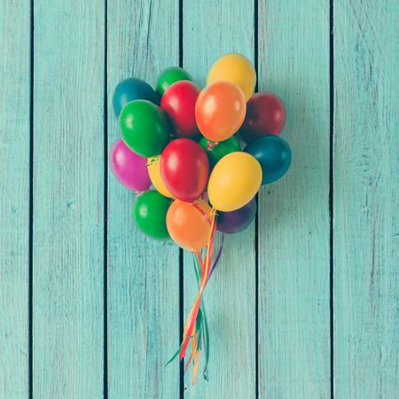 Colorful bunch of Easter egg balloons on blue background