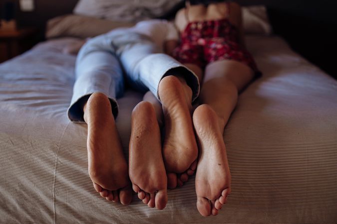 Anonymous barefoot couple on bed