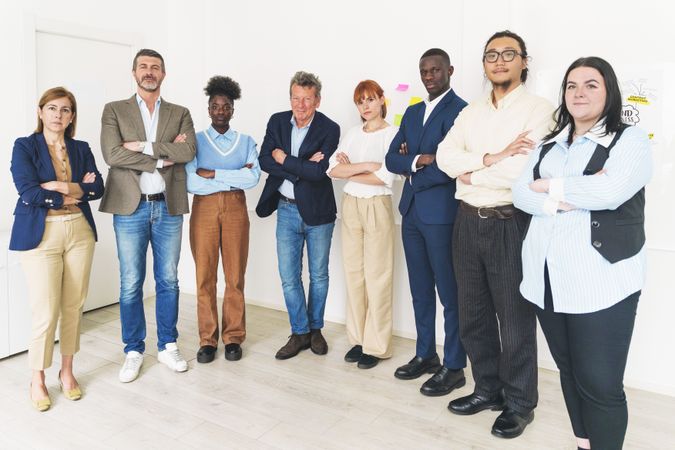 Full-length portrait of a multi-ethnic office team standing with crossed arms