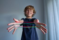 Smiling boy making string figures