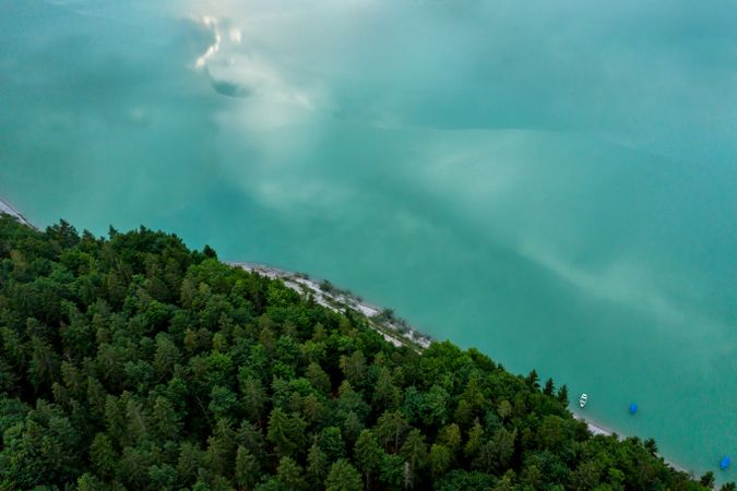 Drone aerial view with Sylvenstein lakeshore and pine forest, in Bavaria, Germany