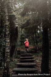 Woman in red jacket running on stairs between trees 0vrQd0