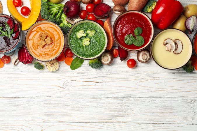 Fresh vegetable soups on rustic table with copy space