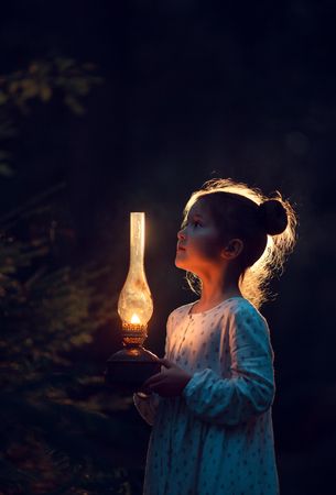 Girl holding oil lamp during the night