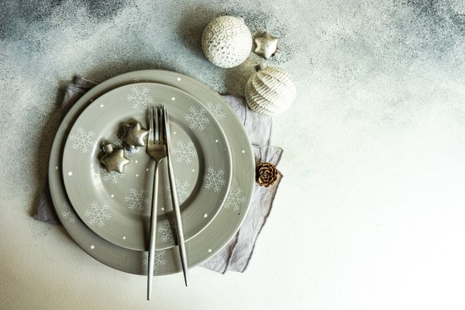 Festive Christmas table setting with baubles and snowflake plate