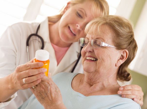Female Doctor or Nurse Explaining Prescription to Older Adult Woman