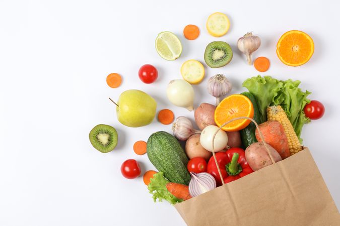 Flat lay with paper bag, vegetables and fruits on background, copy space
