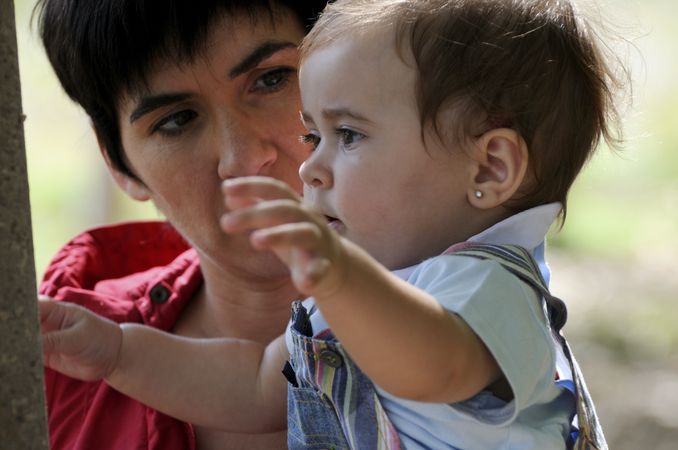 Little girl outreaching her arms with woman