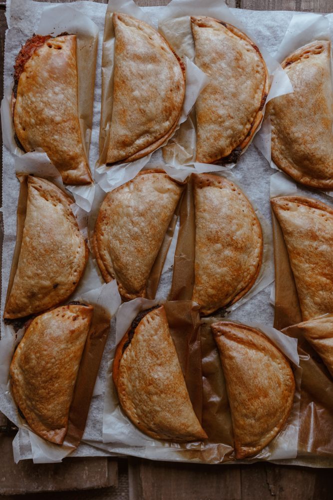 Baking tray with composed freshly baked pies patty