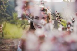 Young happy woman between trees in garden