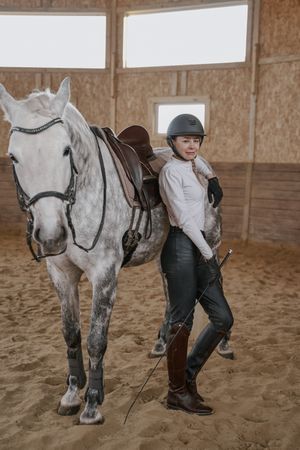 Rider with dapple gray horse in round arena