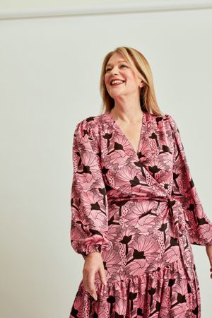 Woman in pink dress smiling in studio portrait
