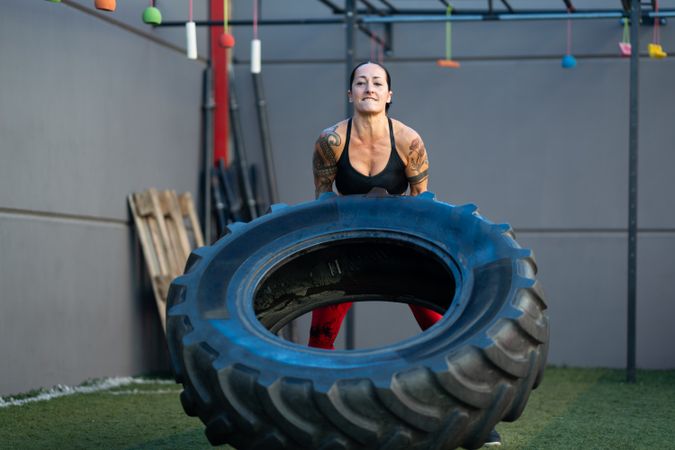 Woman working out by flipping tire