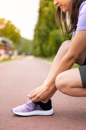 Female athlete tying running shoe laces for running workout