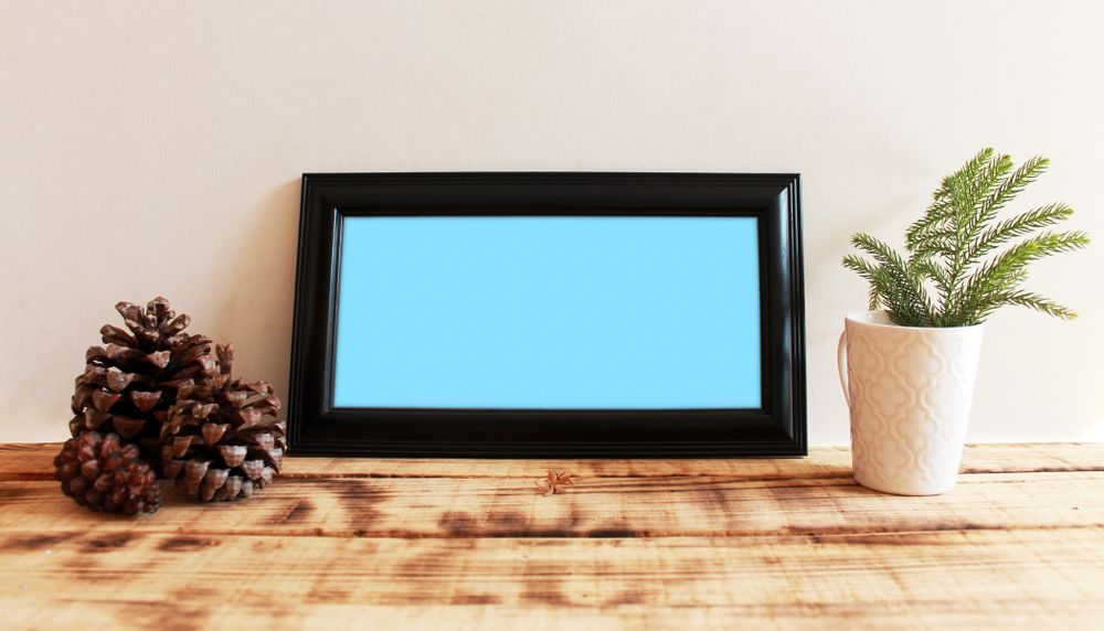 Rectangular long picture frame with blue interior mockup with pinecones and plant