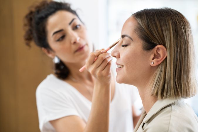 Woman having neutral eye make up applied in spa