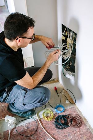 Technician cutting cable to install telecommunication box