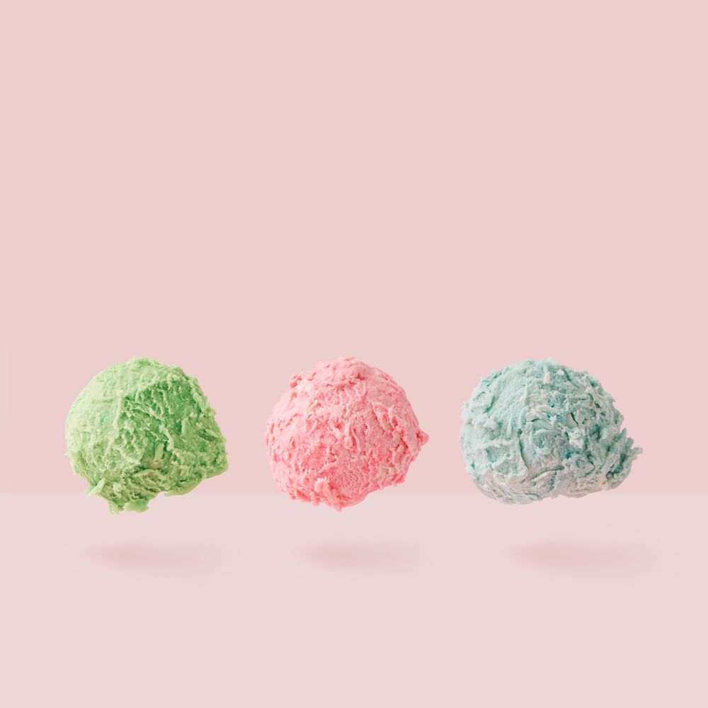 Row of ice cream scoops against pastel pink background