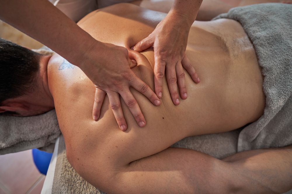 Anonymous masseuse treating client in spa salon