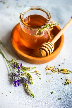 Floral honey with glass of honey and dried flowers