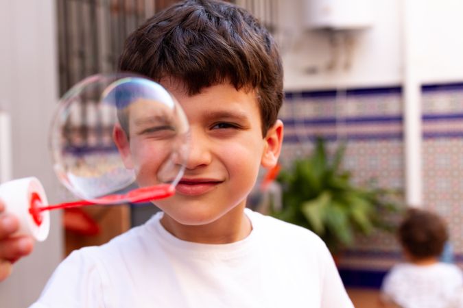 Boy playing with soap bubbles on terrace