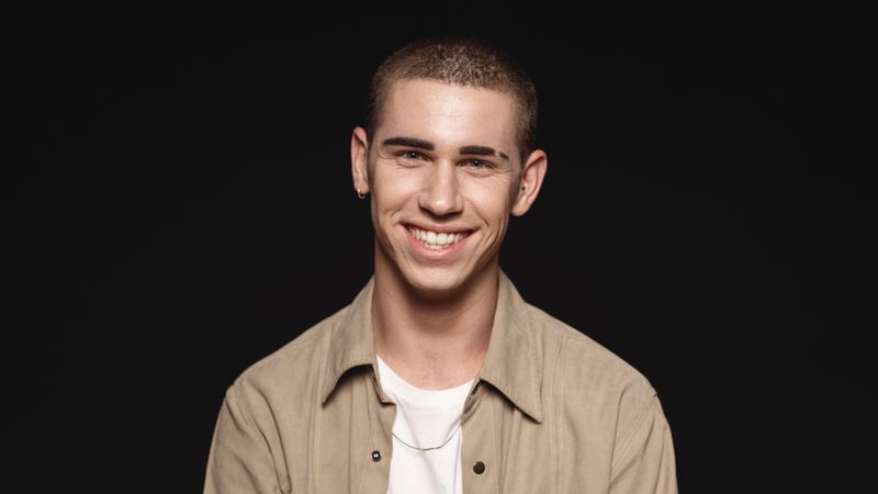 Portrait of smiling young man isolated on dark background