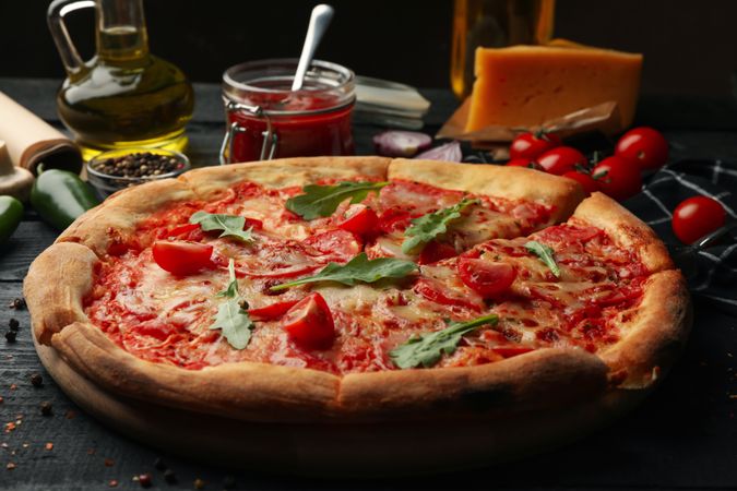 Tasty pizza and ingredients on wooden background
