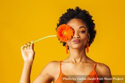 Black woman holding a flower over her eye 48qrZb