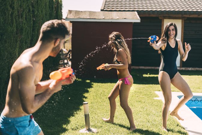 Friends splashing with water guns