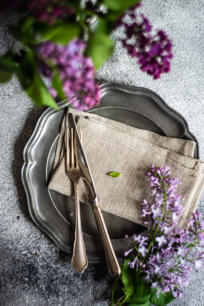 Spring table setting with lilacs on ceramic plate
