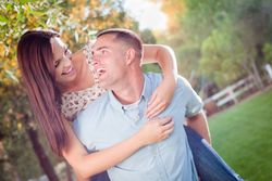 Happy Romantic Couple Piggyback Riding in the Park.