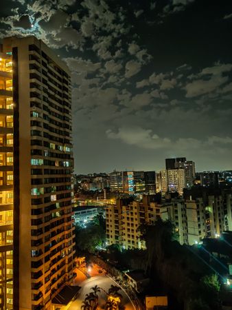 City buildings under gray clouds during night time