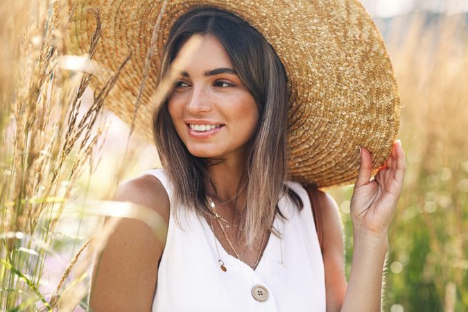 Woman in field wearing a large straw hat