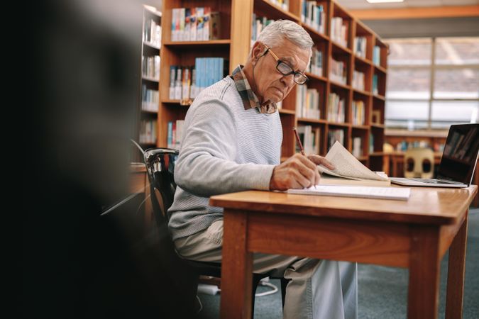 Focused older man studying in college library