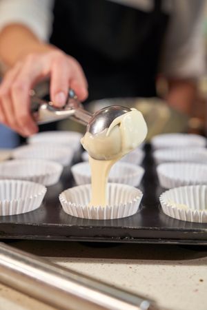 Unrecognizable person pouring batter into baking tray
