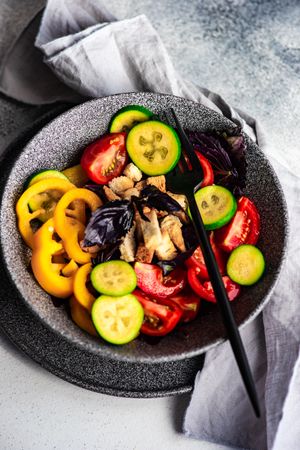 Bowl of healthy gourmet salad with tomatoes, cucumber and yellow peppers