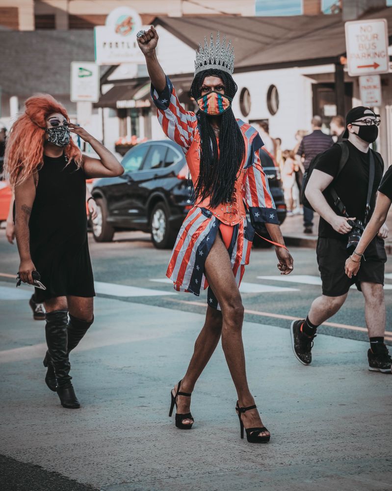 Black drag queen with facemask walking on street during BLM protest in Portland, Maine, USA